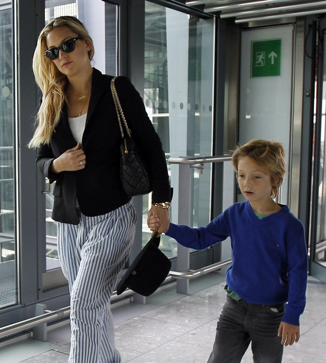 Kate Hudson, blue and white striped pants, black jacket, white shirt, sunglasses, black hat